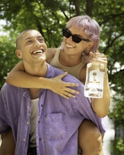man in blue denim button up shirt holding woman in white tank top