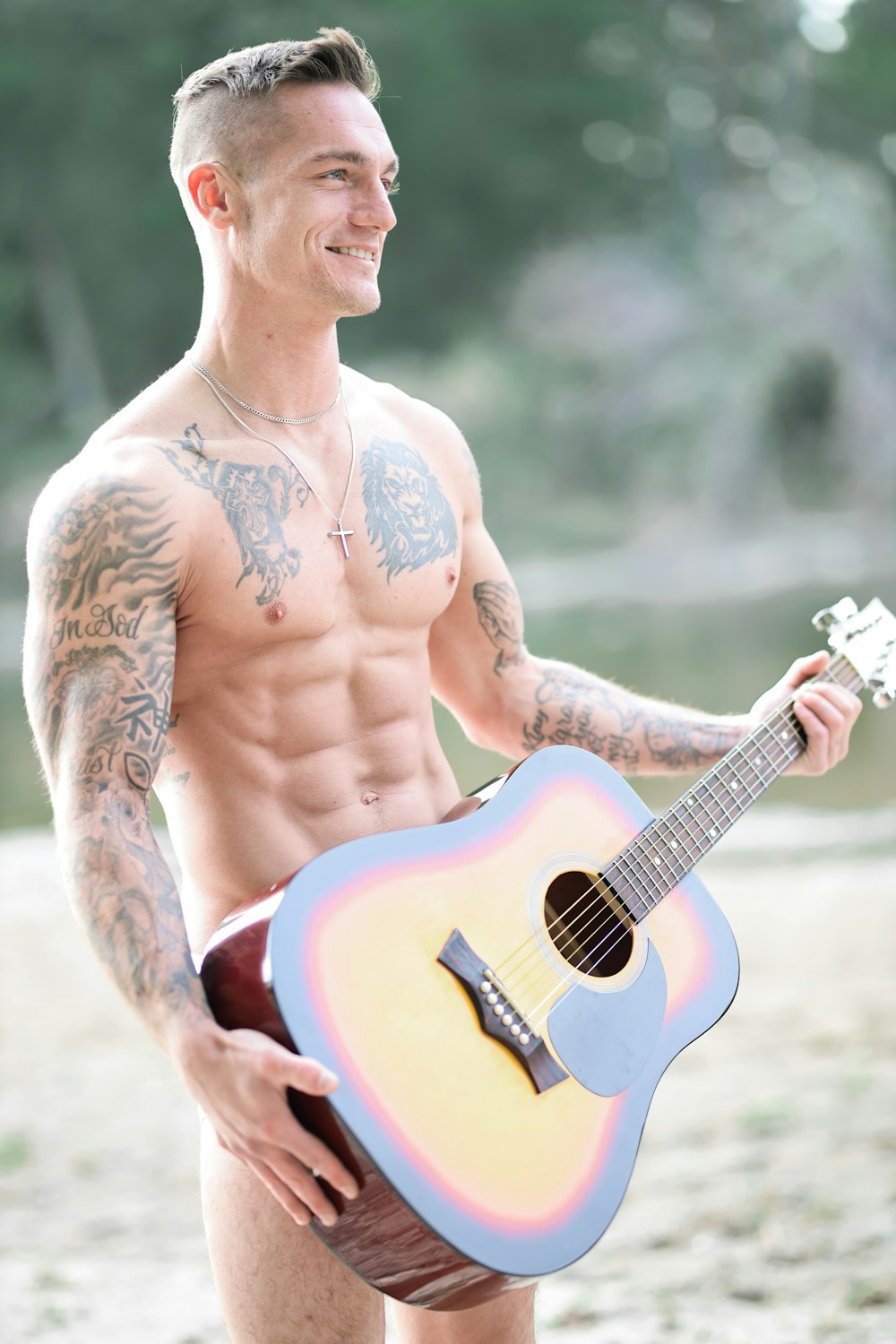 hombre con camiseta blanca sin mangas tocando la guitarra acústica