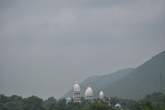 A serene view of a cab parked near a famous temple in Shirdi, surrounded by lush greenery.