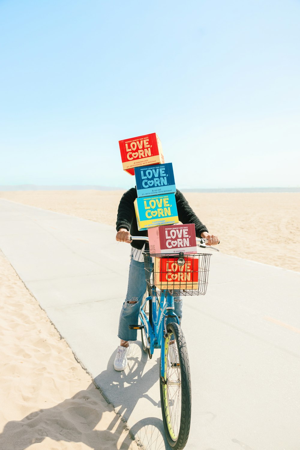 man in black jacket riding bicycle on gray sand during daytime