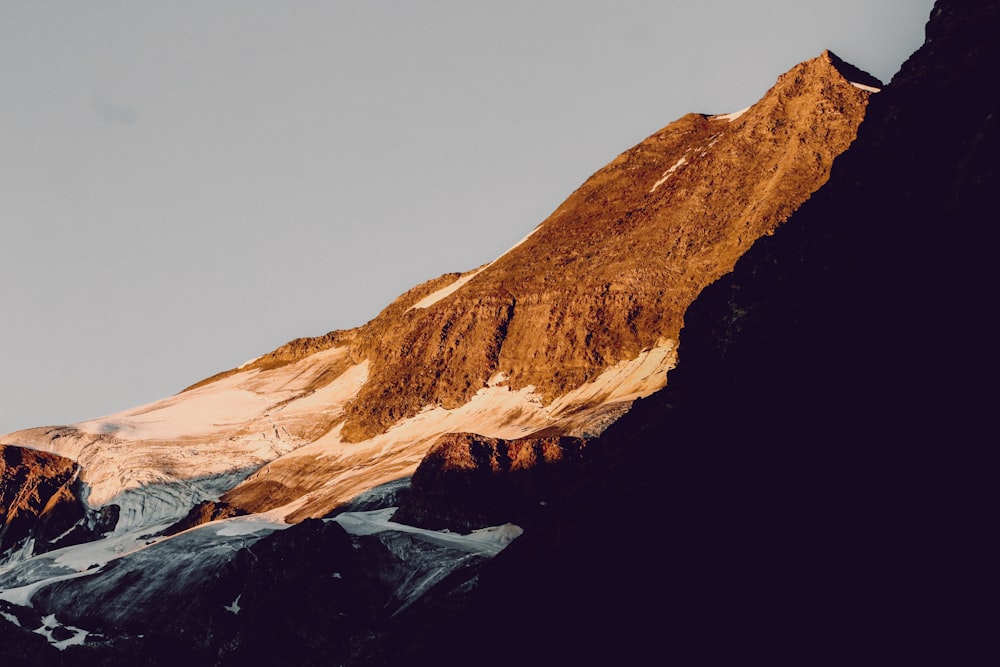 brown rocky mountain under gray sky