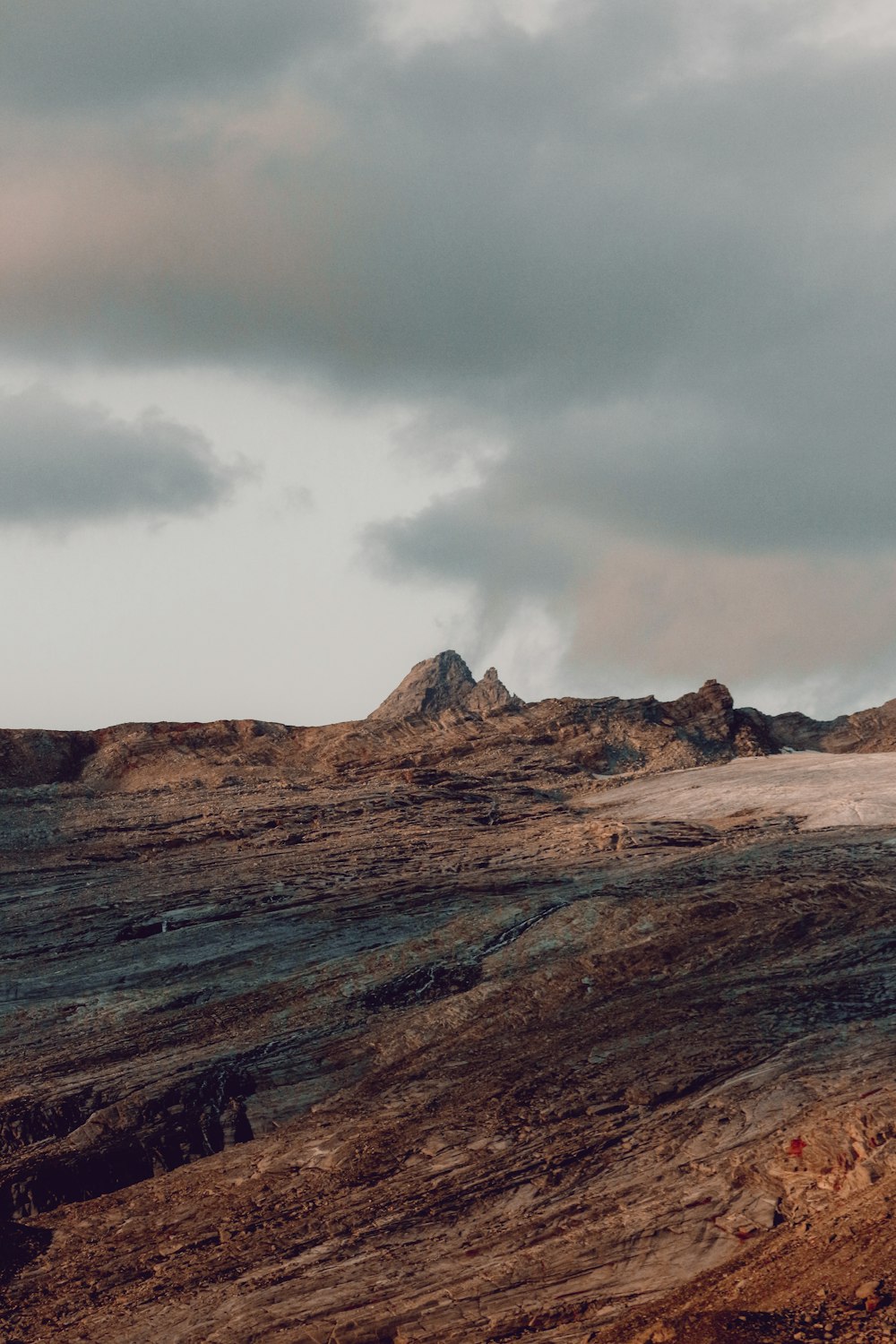 brown and gray mountains under gray clouds