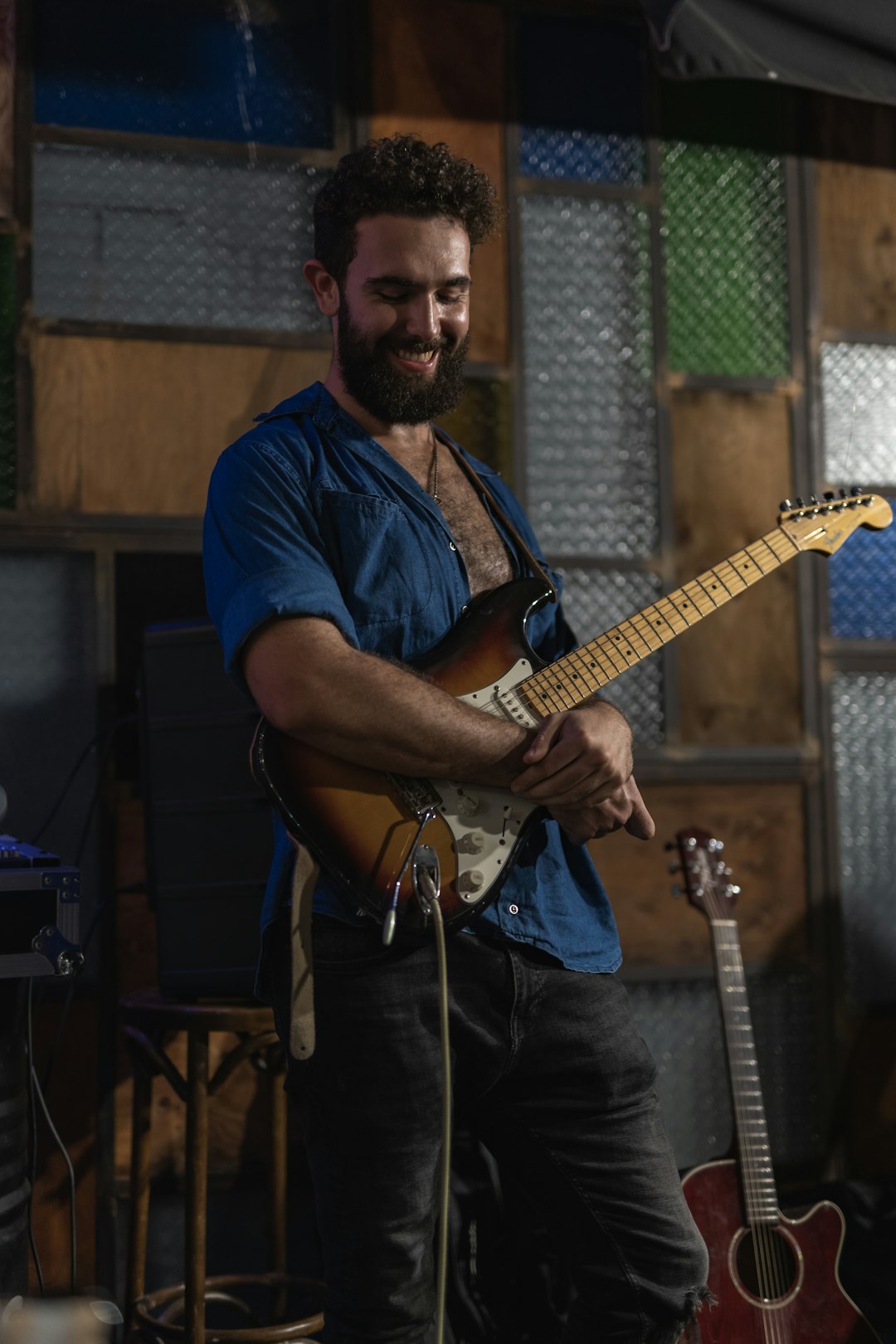 man in blue crew neck t-shirt playing electric guitar
