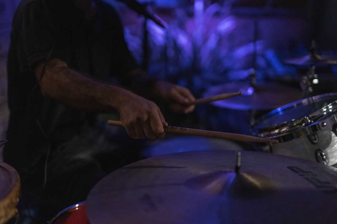 person holding drum stick and drum stick