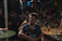 A happy young man enjoying a lively local event in a cozy urban setting.
