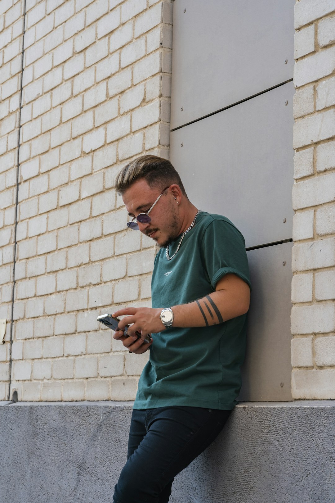 man in green crew neck t-shirt using smartphone