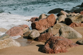 brown and gray rocks on seashore during daytime