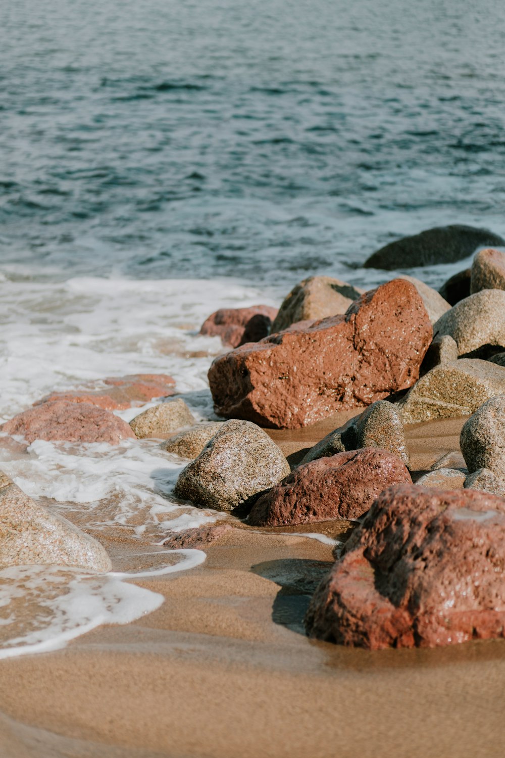 rochas marrons e cinzentas na costa durante o dia
