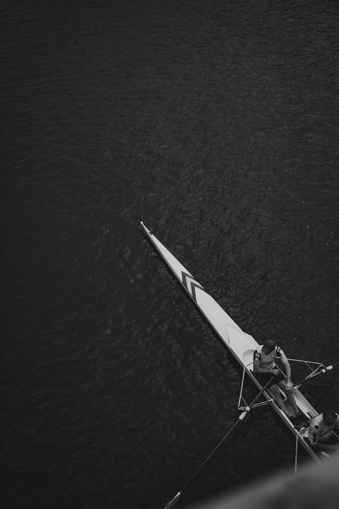 person riding on white and red surfboard in grayscale photography