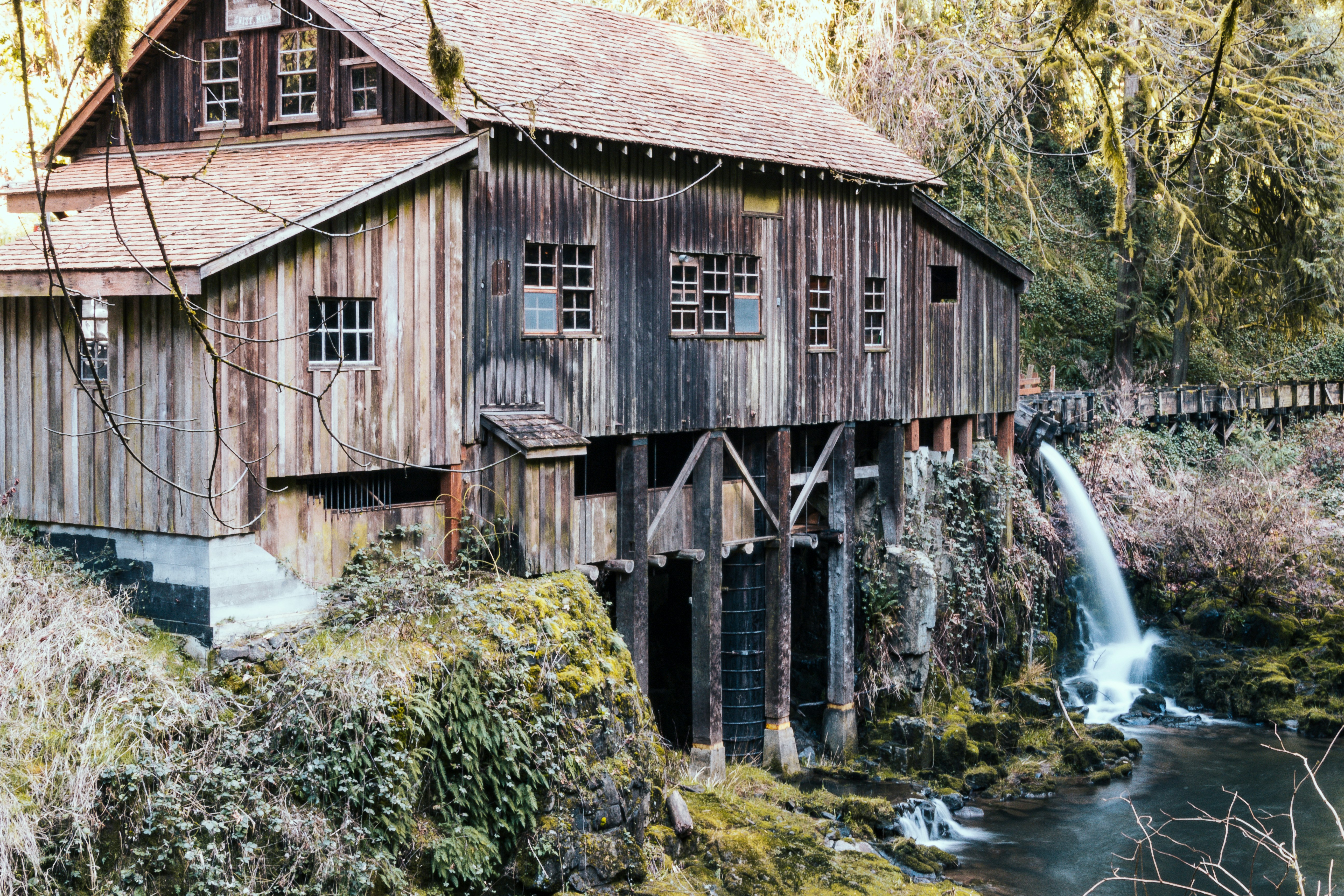 brown wooden house near water falls during daytime