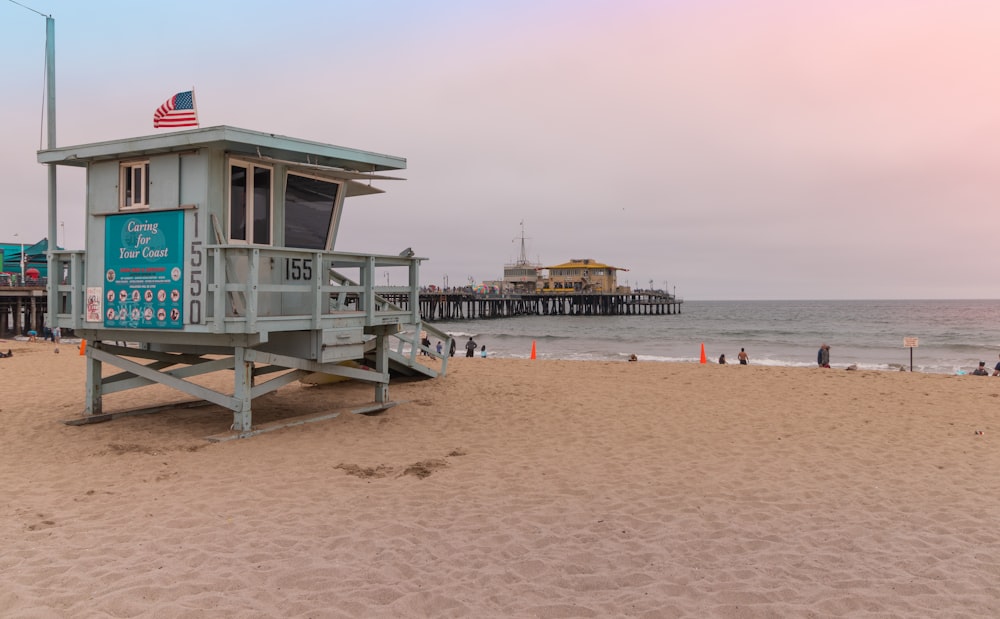 white wooden lifeguard house on beach during daytime