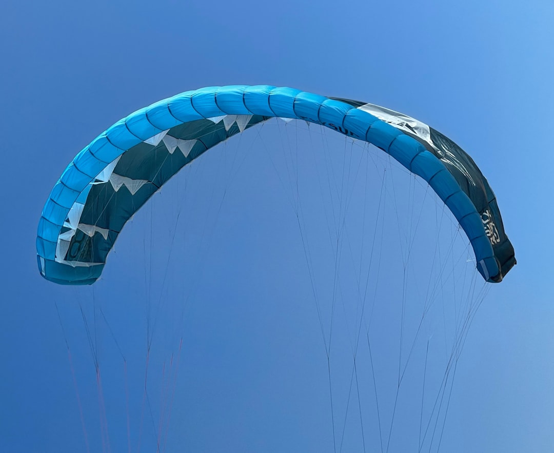 person riding on blue and white parachute
