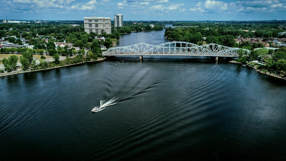white boat on river near bridge during daytime