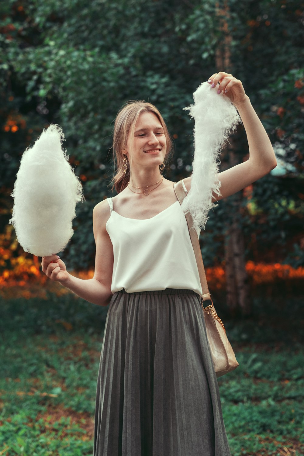 woman in white tank top and black skirt holding white cotton candy