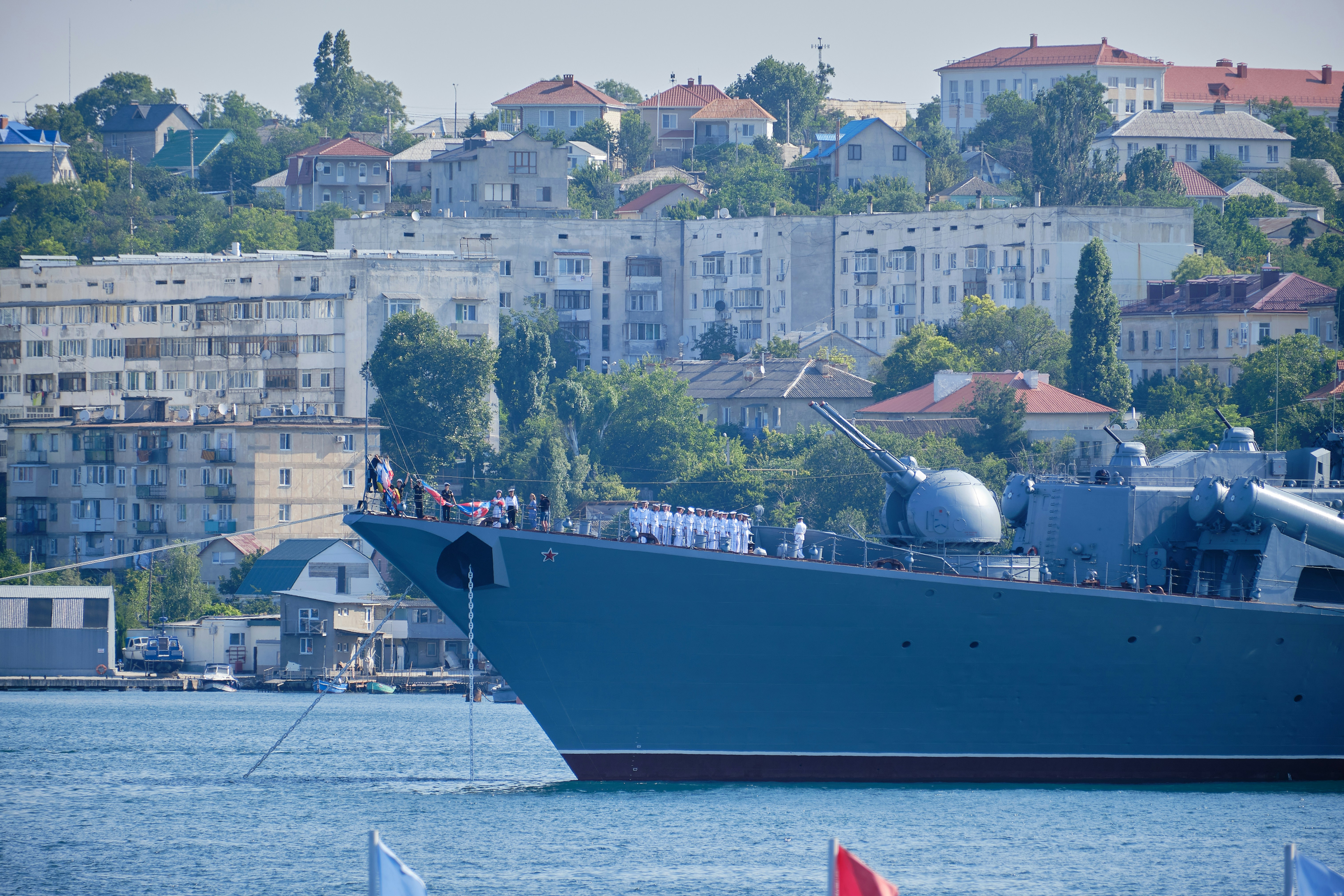 red and white ship on sea near city buildings during daytime