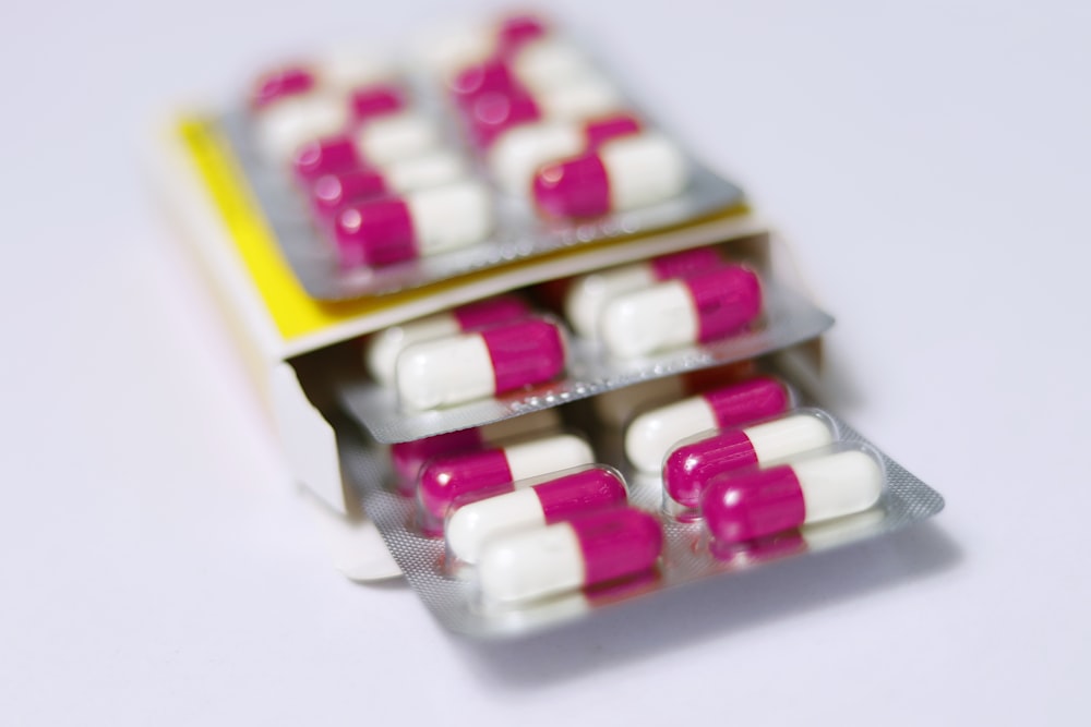 pilule de médicament blanc et rouge sur la boîte jaune