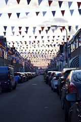 A clean, well-lit Oakland street lined with small businesses proudly displaying patriotic decorations.