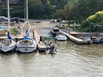 Mobile mechanic van parked near a marina with boats in the background.