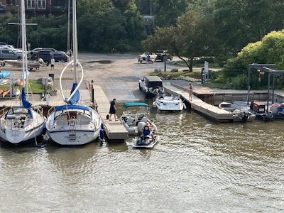 Mobile mechanic van parked near a marina with boats in the background.