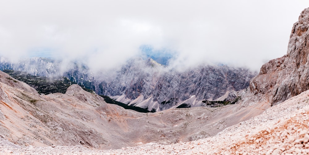 montaña gris y blanca bajo nubes blancas durante el día