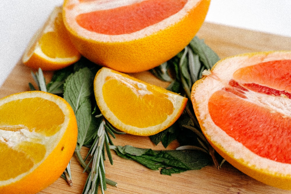 a cutting board topped with sliced oranges and herbs
