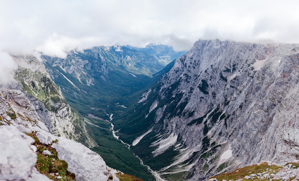 Montañas verdes y grises bajo un cielo blanco durante el día