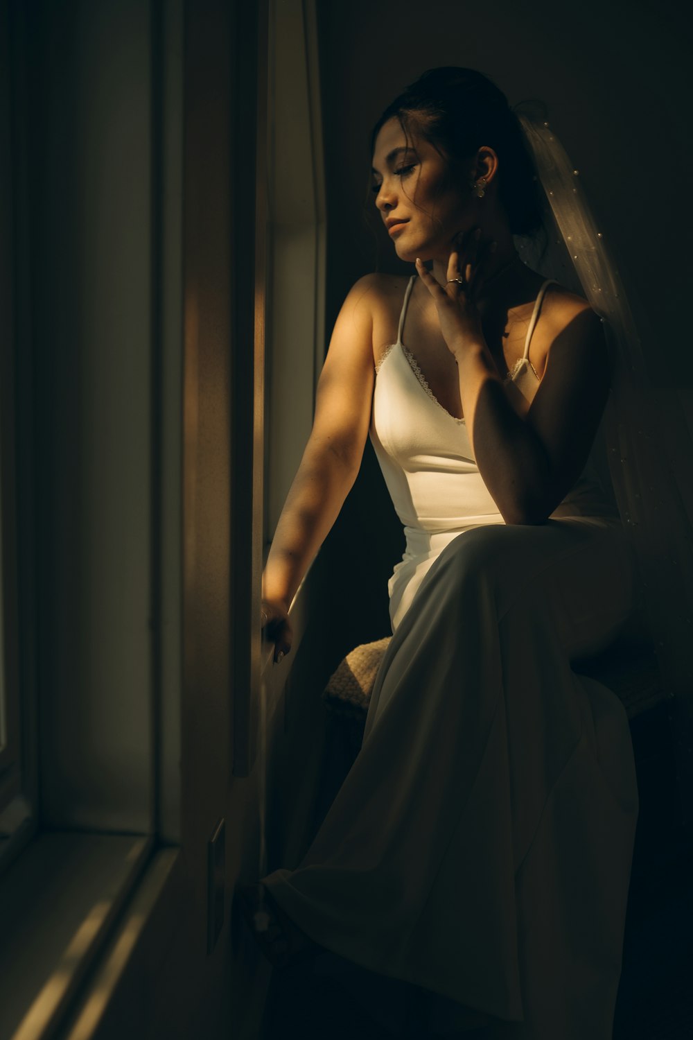 woman in white spaghetti strap dress sitting on chair