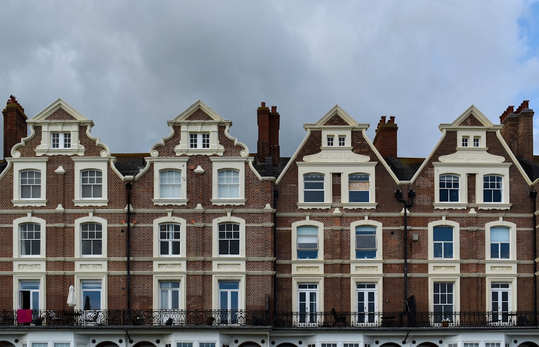 brown and white concrete building under white clouds during daytime