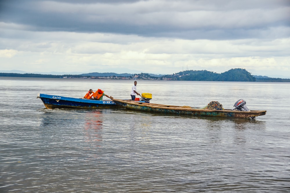 people riding on red kayak on sea during daytime