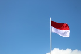 red The Real Truth About Living Permanently in Indonesiaand white flag under blue sky during daytime