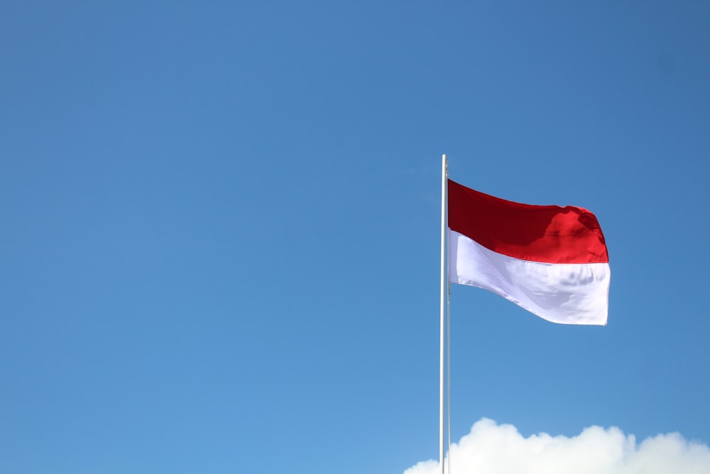 red and white flag under blue sky during daytime