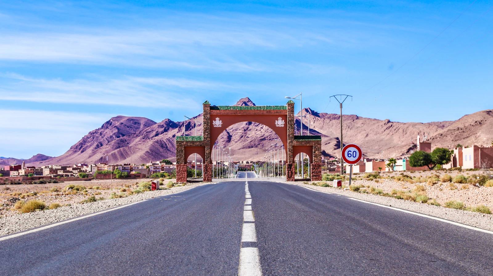 Route d'entrée d'une ville marocaine avec sa porte monumentale