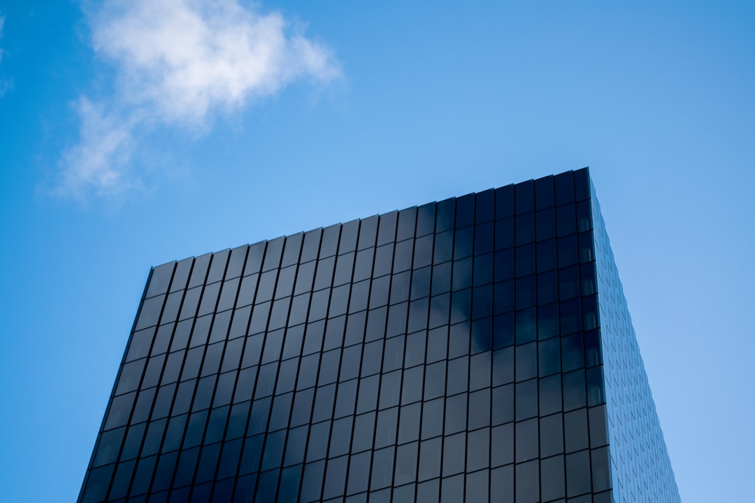 blue and white glass walled high rise building