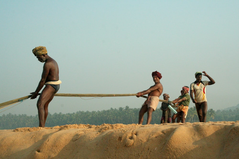 people sitting on brown rock near body of water during daytime