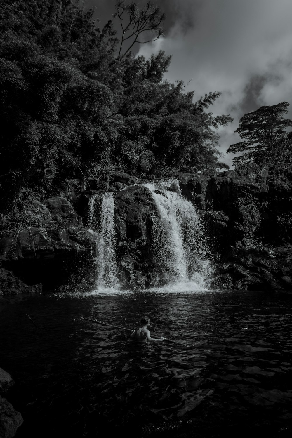 grayscale photo of woman in water falls
