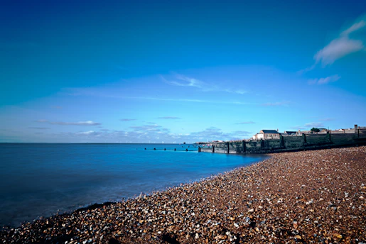 Cozy seaside guesthouse with sandy beach visible in the background under a clear sky.