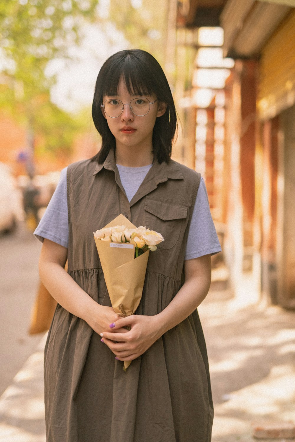 woman in blue button up shirt holding brown paper bag