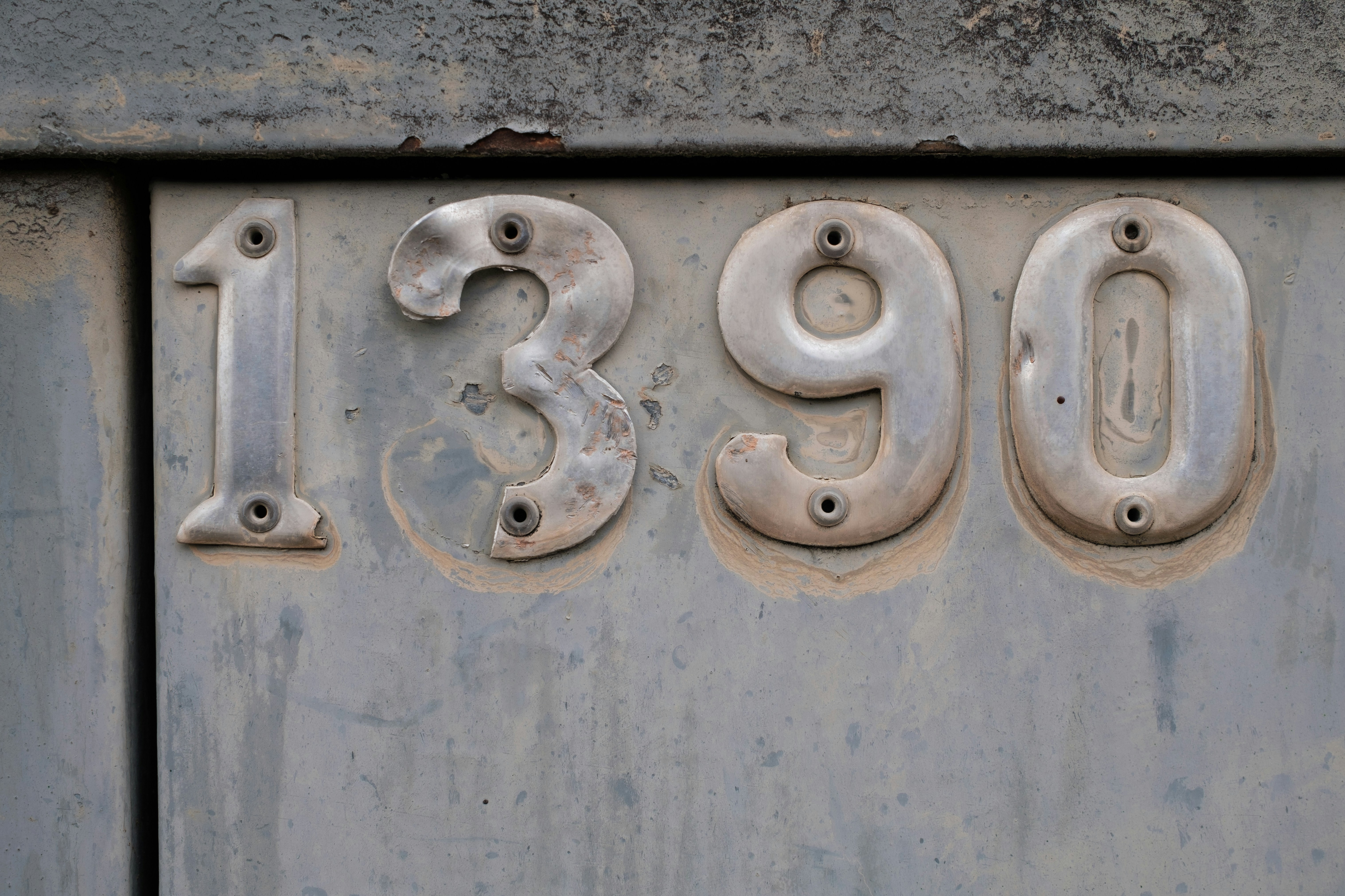 The numbers 1390 riveted onto metal.