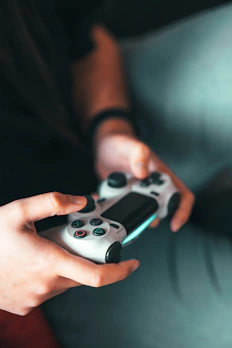 A happy gamer holding an Xbox controller, immersed in gameplay at home.