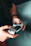 A happy gamer holding a PlayStation controller with a bright smile in a cozy room.