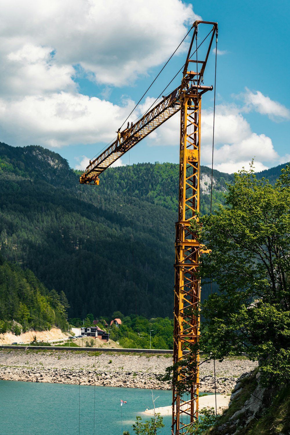 yellow crane near green trees during daytime