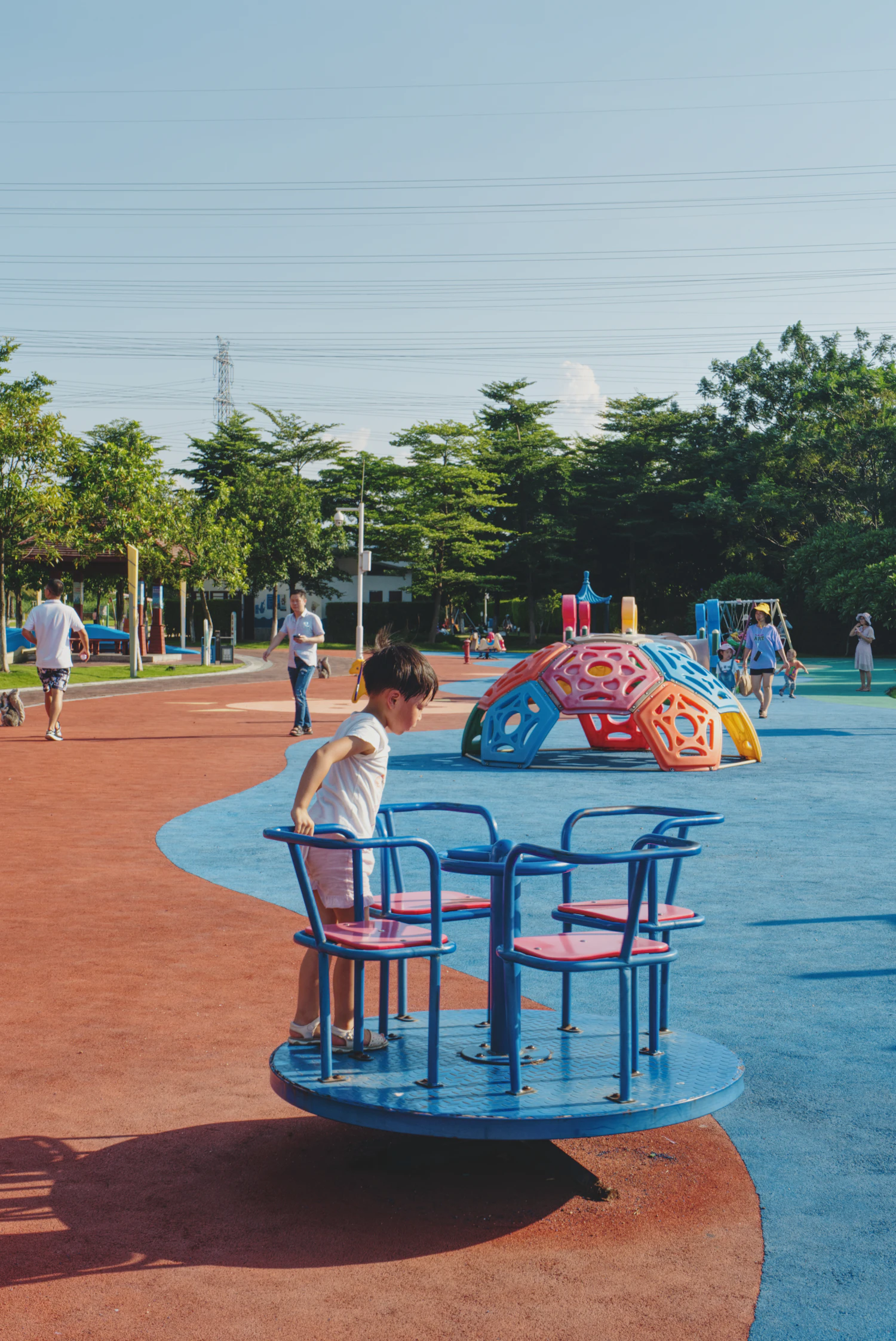 Child approaching a spinning roundabout at a playground