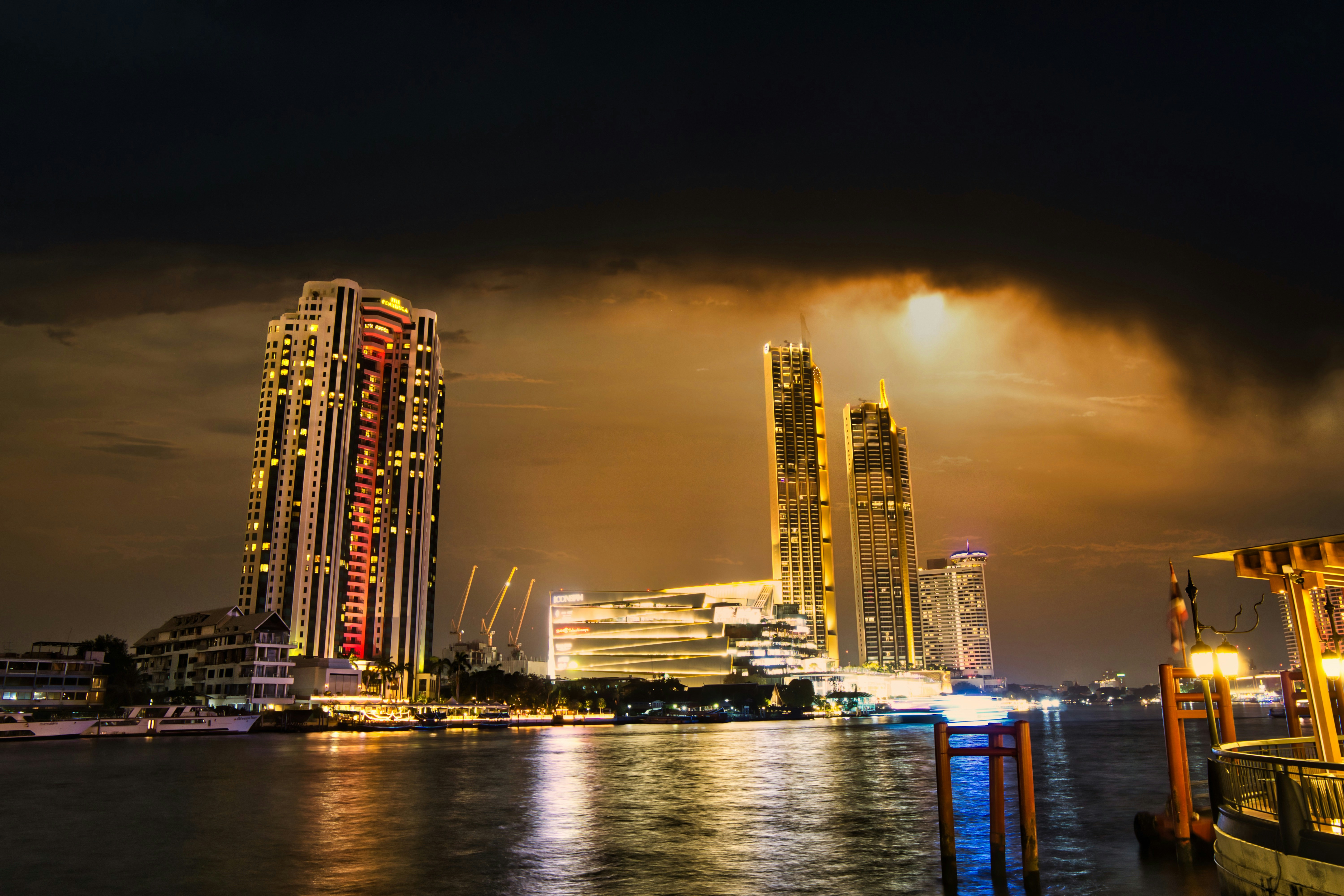 city skyline across body of water during night time