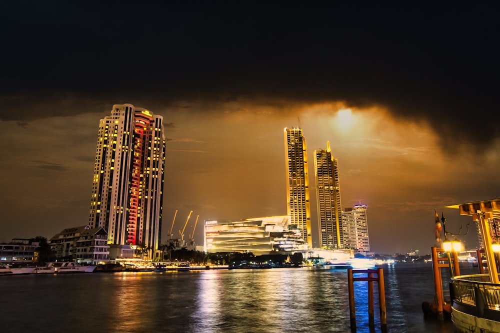 city skyline across body of water during night time