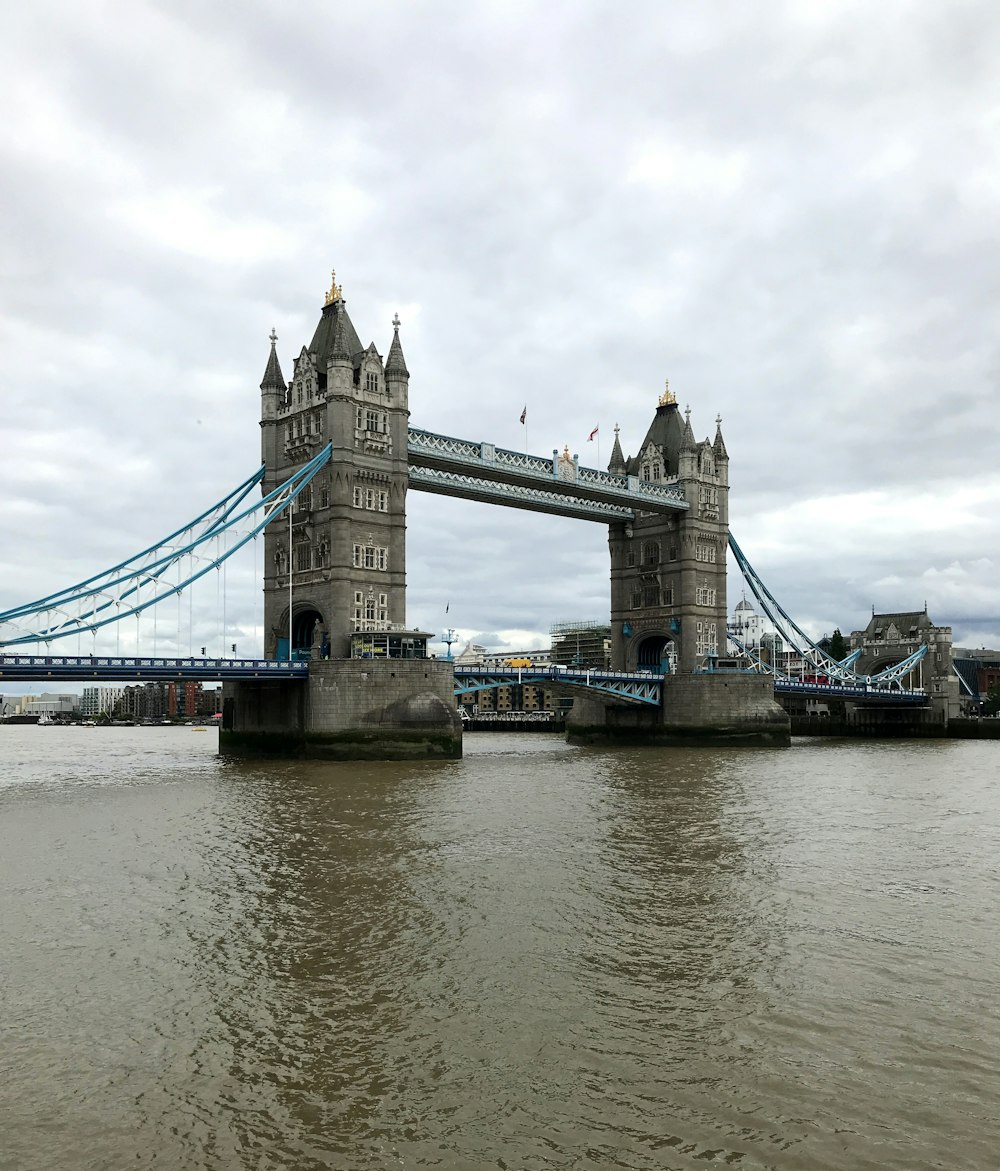 puente de hormigón gris sobre el río bajo el cielo nublado durante el día