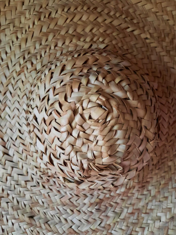 An artisan carefully crafting a delicate paja toquilla hat with traditional techniques.