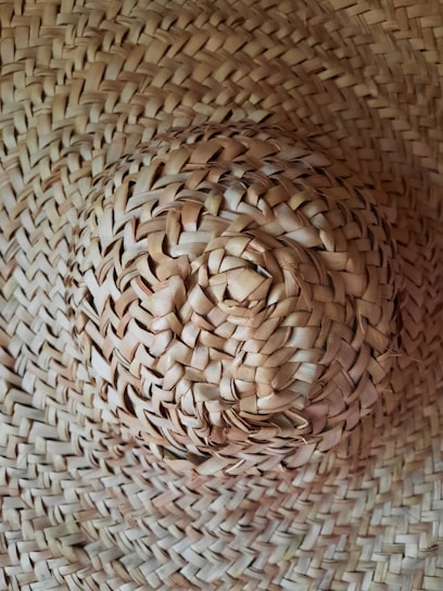 A close-up of a beautifully crafted handmade hat resting on a rustic wooden table.