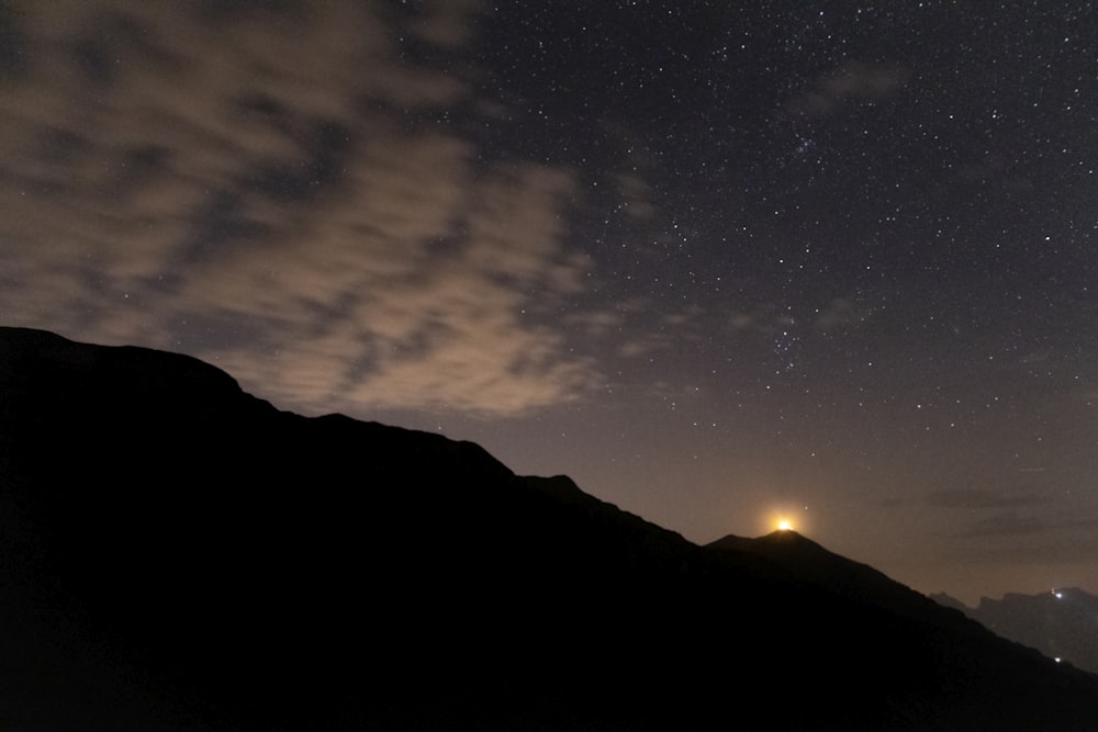 Silhouette des Berges unter blauem Himmel mit Sternen während der Nacht