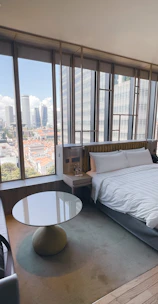 Luxurious deluxe suite with plush furnishings and a balcony overlooking the city skyline.