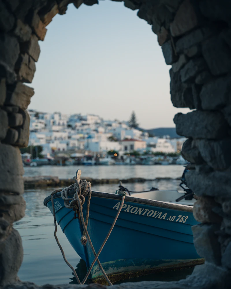 Blue wooden boat moored on clear Aegean water